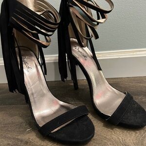 Black open toe heels with fringe on the back